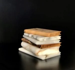 Une pile de livres anciens aux tranches usées, posés sur fond noir.