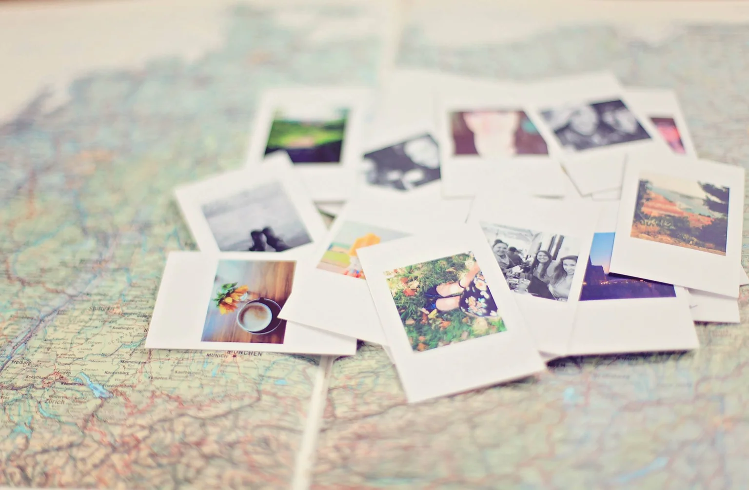 Des photographies instantanées éparpillées sur une carte routière dépliée.